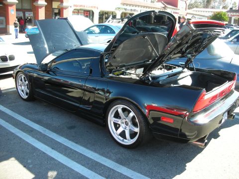 1998 Ford Crown Victoria - black Acura NSX with front hood and rear engine hatch open, parked in front of storefronts at a morning car meet.