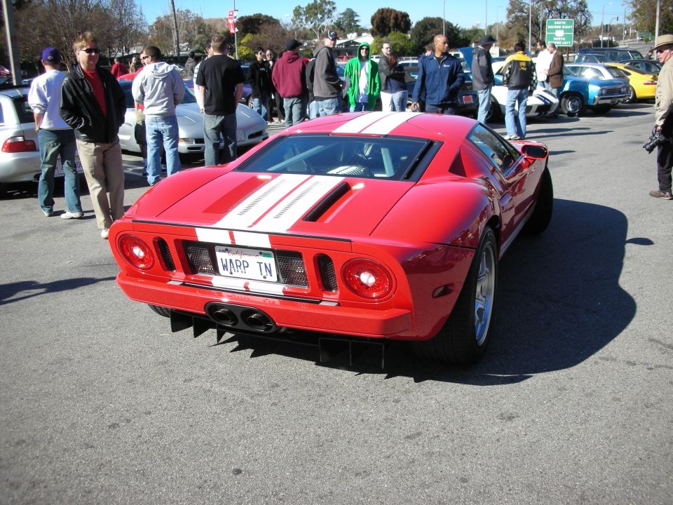 Red Ford GT with white stripes, rear view, vanity plate reading WARP TN