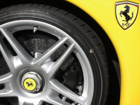 1998 Ford Crown Victoria - Detail of a yellow Ferrari's front wheel, drilled brake disc and fender showing the prancing-horse shield emblem.