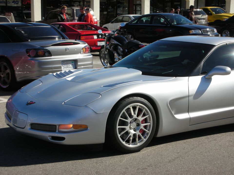 Silver Chevrolet Corvette C5 front three-quarter with thin-spoke wheels at a car meet
