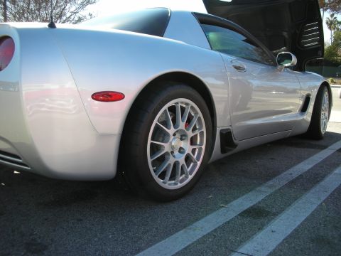 1998 Ford Crown Victoria - Side-rear view of a silver Corvette C5 lowered on lightweight silver wheels with a red brake caliper in a parking lot.