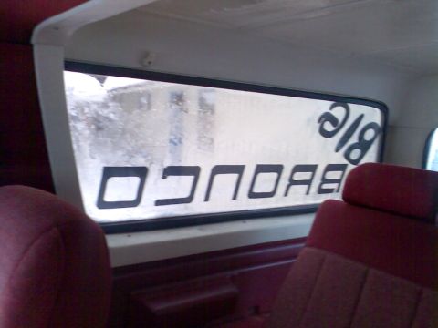 1989 Ford Bronco - View from inside a Bronco, showing the rear window with custom lettering.