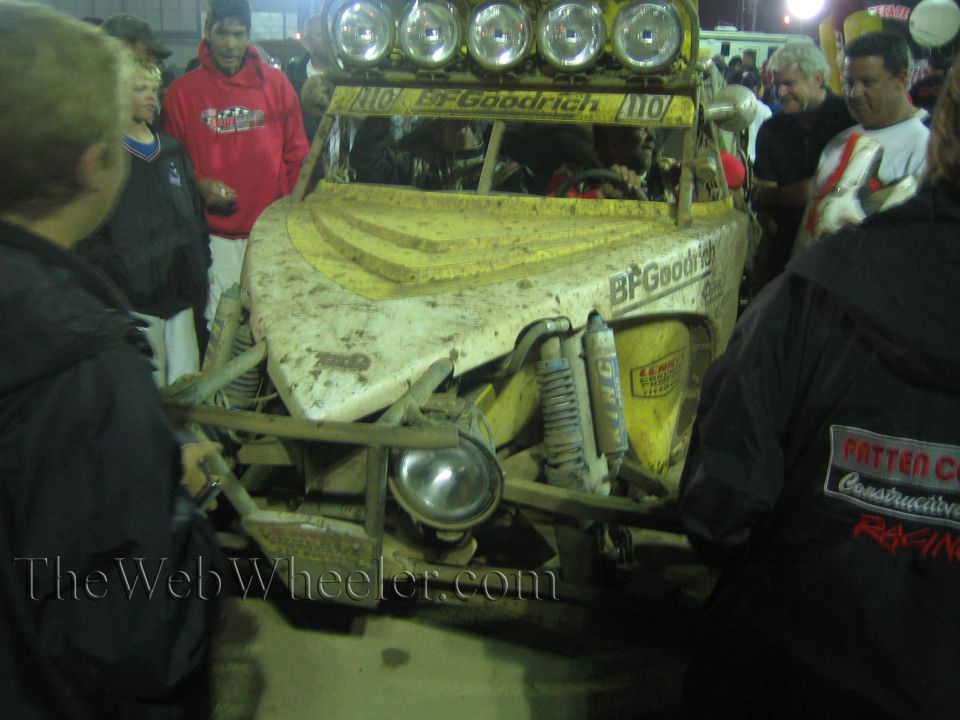 Front of mud-covered yellow off-road buggy with BFGoodrich decals at night