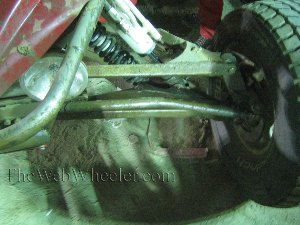 Close-up of off-road buggy suspension showing coilover shock, control arms and tire
