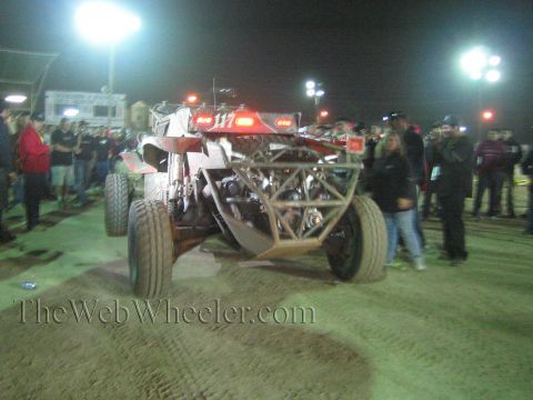 Front view of tube-frame off-road buggy 117 with spectators at a floodlit night event
