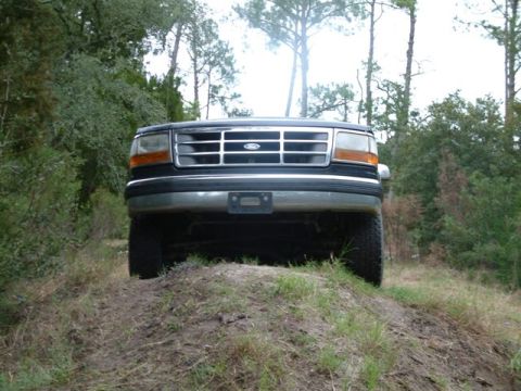 1992 Ford Bronco - This 1992 Ford Bronco navigates an off-road trail, its front grille and headlights.