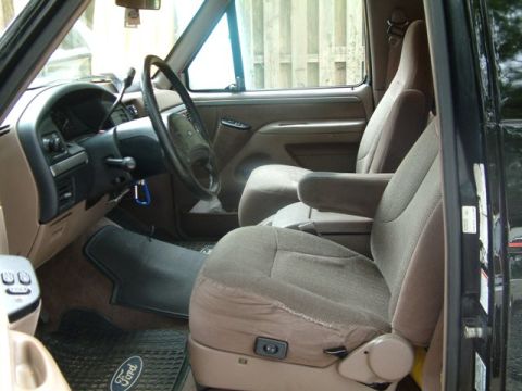 1992 Ford Bronco - The interior of a 1992 Ford Bronco features cloth seats and a tan dashboard.