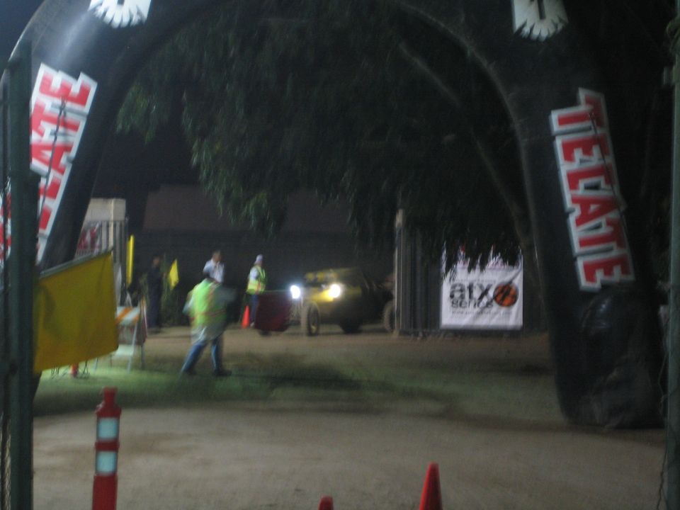 Off-road vehicle with headlights entering a Tecate-arched course