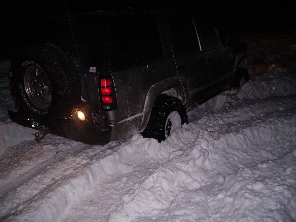SUV stuck in deep snow, spare tire mounted on back