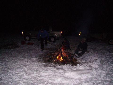 2000 Chevrolet Tahoe - People enjoy a campfire in the snow with a truck nearby.