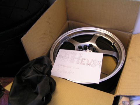 1993 Ford Probe - A single car wheel is shown inside a cardboard box with a handwritten note.