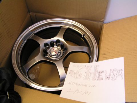 1993 Ford Probe - A single silver five-spoke aftermarket wheel with a red center cap is shown inside a cardboard box.