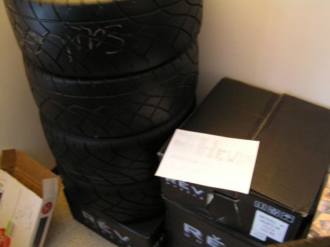 1993 Ford Probe - Four tires stacked next to boxes, with "REVS" on the tires and "SUPERMOTORS.NET" on a box.