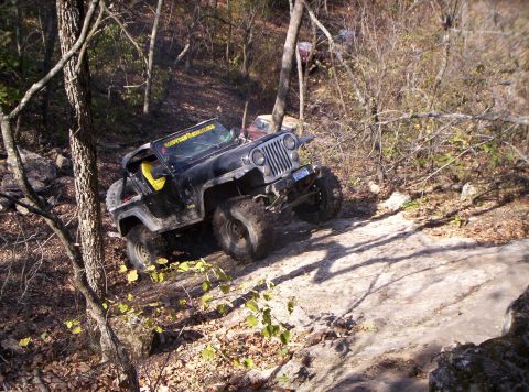 1981 Jeep CJ7 - A modified Jeep navigates a challenging off-road trail with steep inclines and rocky obstacles.
