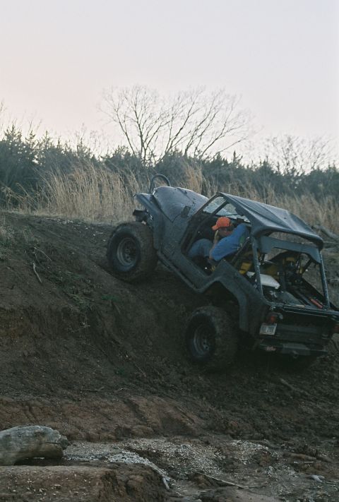 1981 Jeep CJ7 - A black Jeep CJ navigates an off-road incline with a driver at the wheel.
