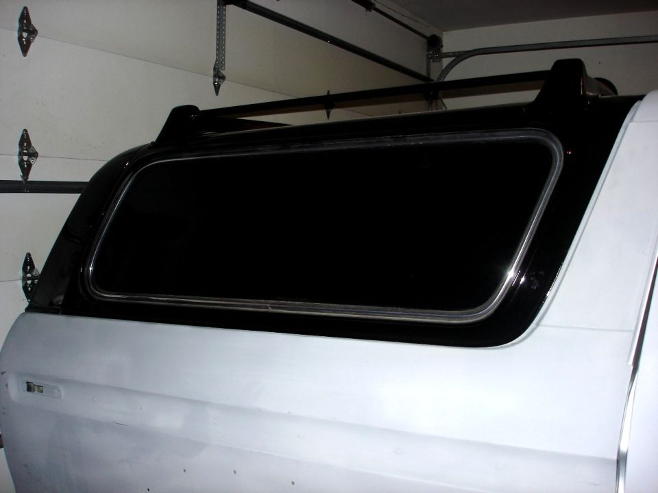 White 1979 Ford Bronco rear quarter panel and window with black camper shell