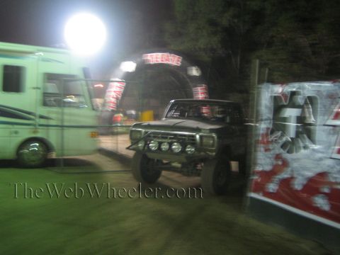 Lifted off-road truck with front light bar by Tecate arch at night