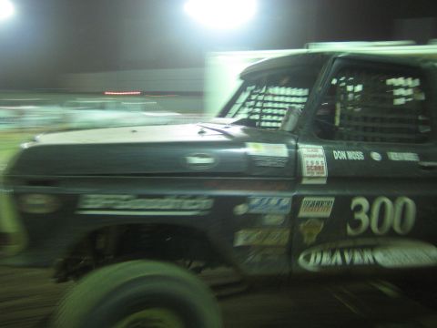 Side profile of black Ford race truck number 300 with Deaver and sponsor decals at night
