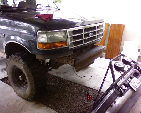1995 Ford Bronco - Front view of a 1995 Ford Bronco with the bumper detached, revealing the grille and headlights.
