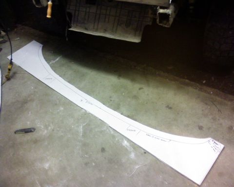 1995 Ford Bronco - A paper template, likely for a vehicle part, lies on a concrete floor next to a utility knife.