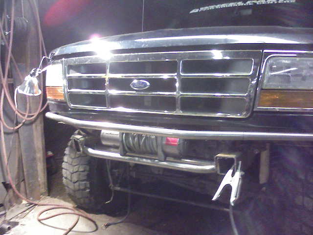 Black Ford Bronco front grille with chrome accents and a winch mounted on a custom bumper