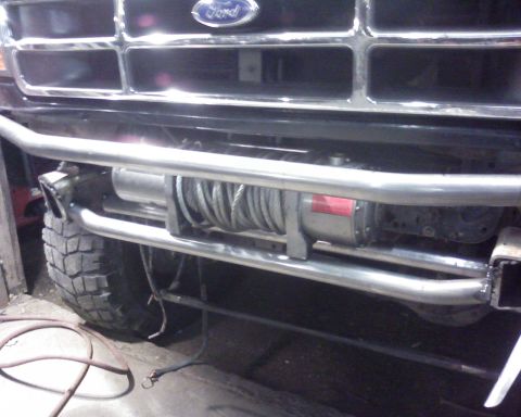 1995 Ford Bronco - The front bumper of a 1995 Ford Bronco features a winch and a custom brush guard.
