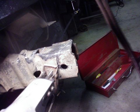 1995 Ford Bronco - A close-up view of a damaged vehicle frame section and an open red toolbox containing various tools.