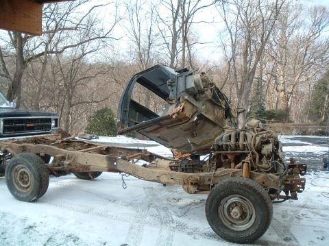 1989 Ford F-250 - This heavily damaged truck chassis is missing its body panels, with the cab tilted back to expose the engine.