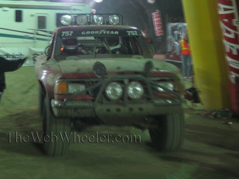 Mud-covered off-road race truck number 757 with Goodyear decal at night