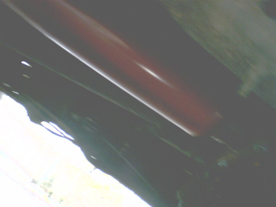Underside view of vehicle with red shock absorber