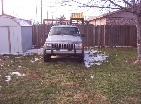 1987 Jeep Cherokee - Front view of a 1987 Jeep Cherokee in a backyard setting with patchy snow.