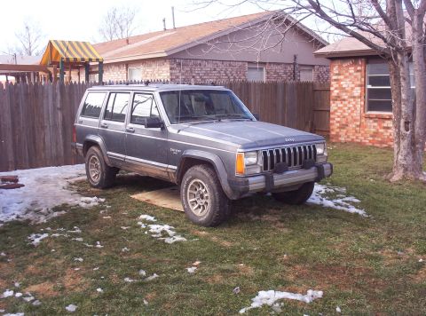 1987 Jeep Cherokee - This Jeep Cherokee is parked in a residential backyard during a time with some snow on the ground.