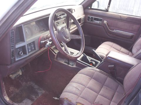 1987 Jeep Cherokee - Interior view of a 1987 Jeep Cherokee, plaid upholstery and the dashboard.