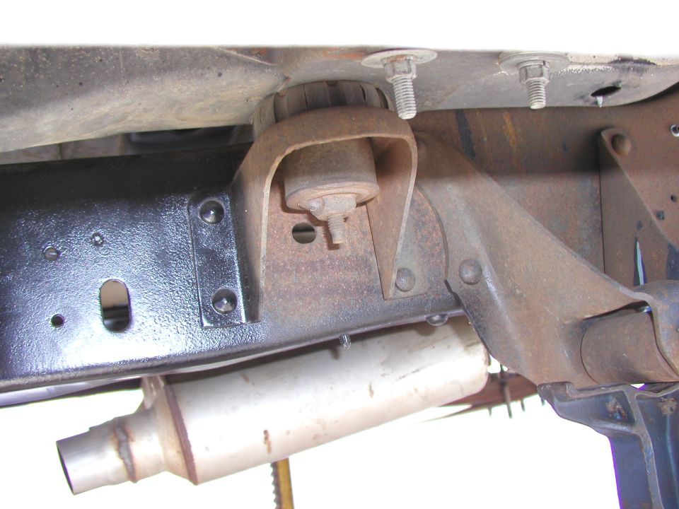 Close-up of vehicle frame with body mount and exhaust pipe