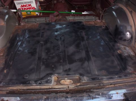 1987 Jeep Cherokee - Interior cargo area of a vehicle, showing the floor and some rust damage.