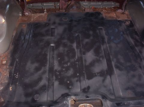 1987 Jeep Cherokee - The interior floor pan of a vehicle shows significant rust and wear.