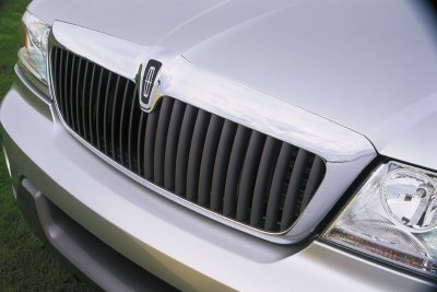 2003 Lincoln Aviator - The front grille and headlight assembly of a silver Lincoln vehicle is shown in this close-up shot.