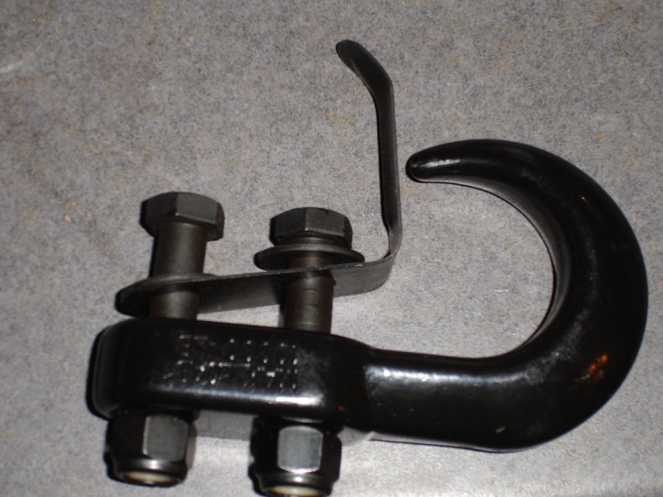 Black tow hook assembly with two bolts and nuts. Text is visible on the hook