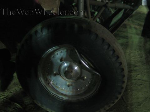 Close-up of an off-road vehicle wheel and tire with a smooth metal hub at night