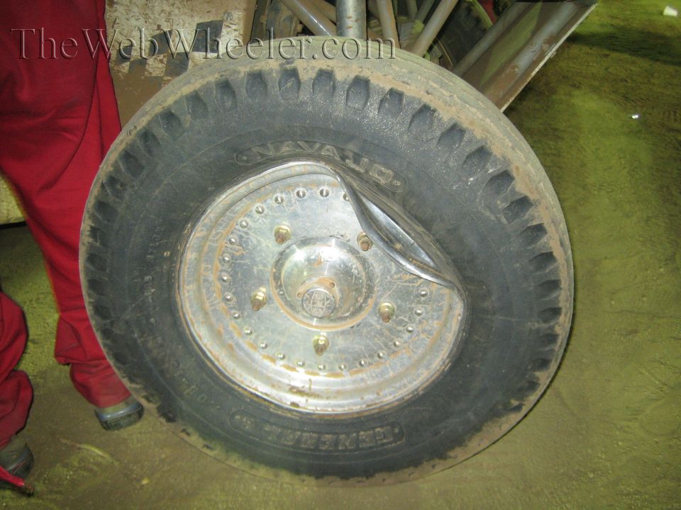 Close-up of a Navajo off-road tire on a riveted metal disc wheel