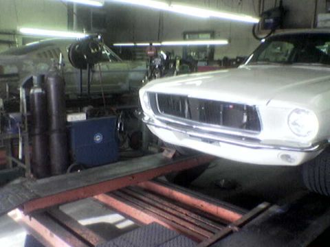 1988 Ford Bronco - A white classic car is being worked on in a garage, with another vehicle in the background.