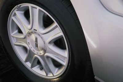 2003 Lincoln Aviator - Close-up of a silver Lincoln wheel and fender, showing the 'LINCOLN' branding on the hubcap.