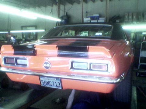 1988 Ford Bronco - Orange 1967 Camaro SS with black racing stripes and California plates is shown from the rear.