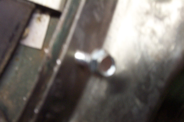 Close-up of a bolt threaded into a metal bracket