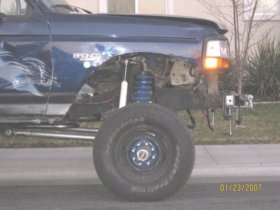 Blue Ford Bronco with front fender removed exposing coilover suspension and BFGoodrich tire