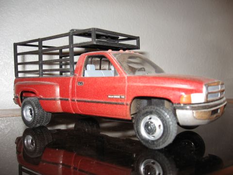 1977 Ford F-150 - A model pickup truck with a cage bed attachment sits on a reflective surface.