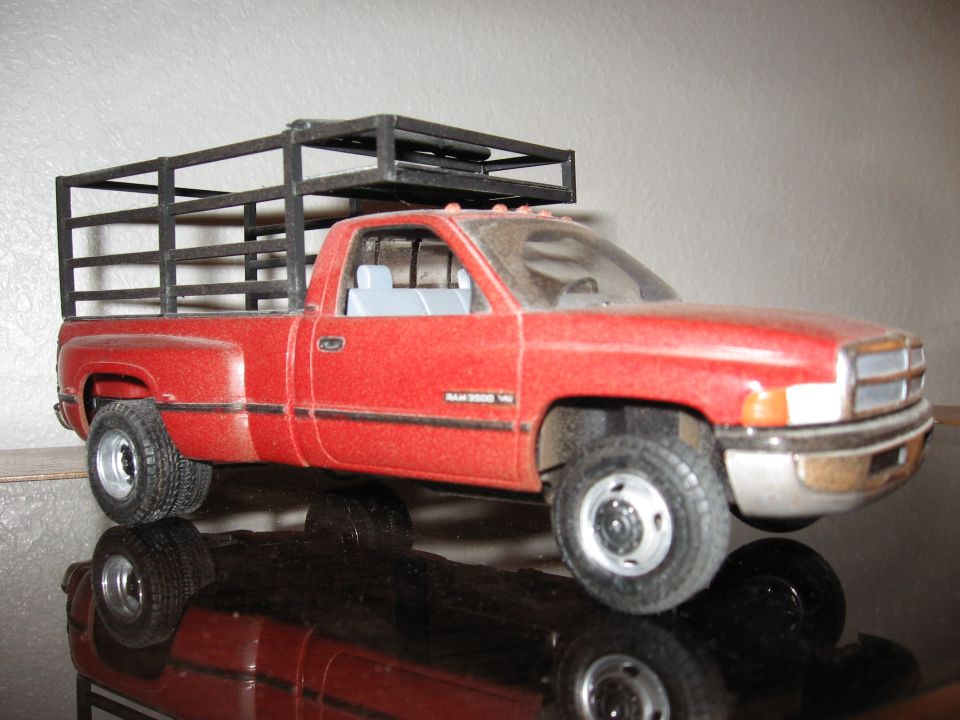 Red pickup truck model with a black cage in the bed