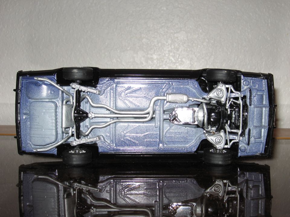 Underside of a black model car, showing suspension and exhaust system