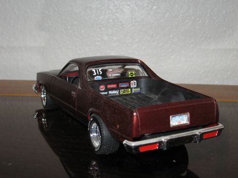 1977 Ford F-150 - Model car with racing stickers, including Holley and Auto Meter, displayed on a reflective surface.