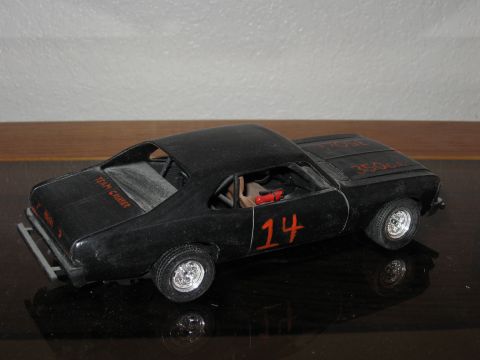 1977 Ford F-150 - A black model car with racing decals sits on a reflective surface.